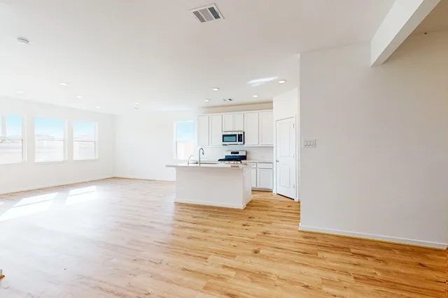 a view of large kitchen with wooden floor and windows