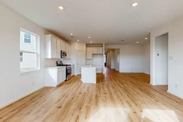 a large kitchen with a sink and a refrigerator