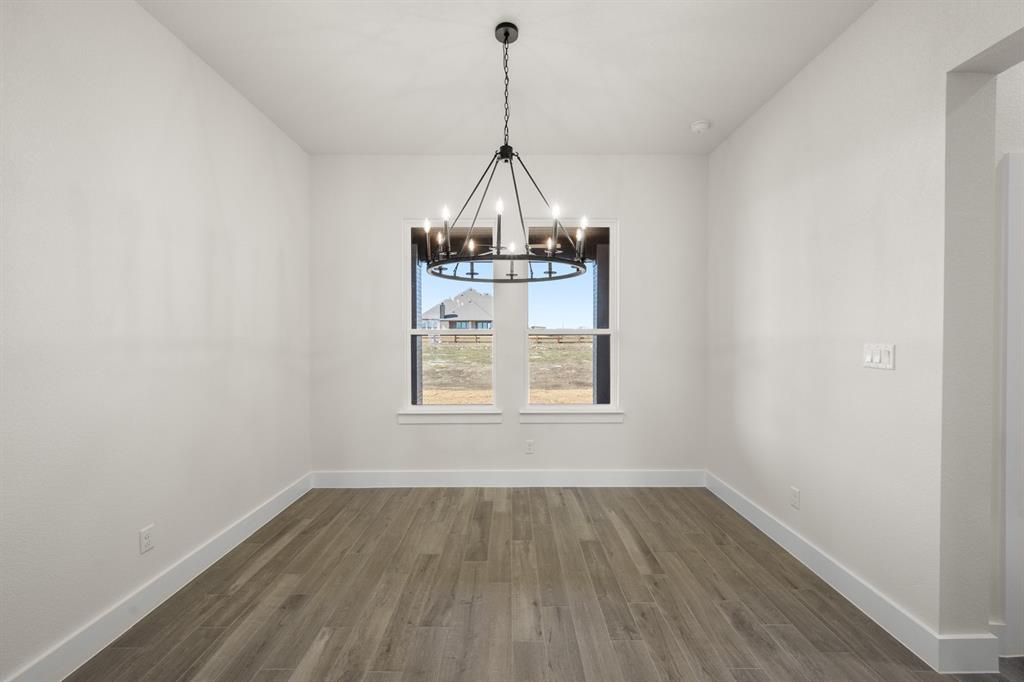 4867 Prairie Sky Lane DISH, TX 76247 - Photo 14 of 27 a view of a room with wooden floor a chandelier and windows