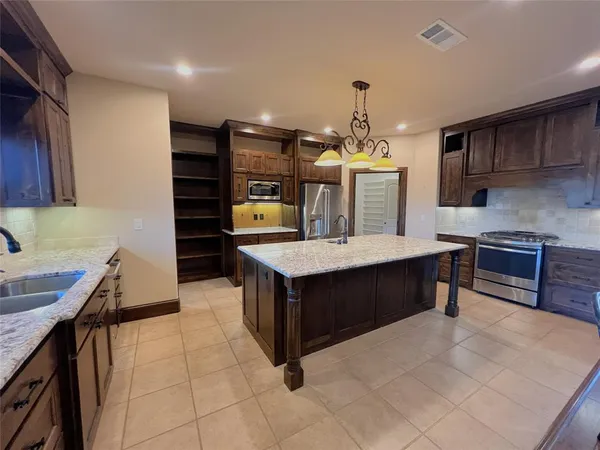 a kitchen with granite countertop a stove and cabinets