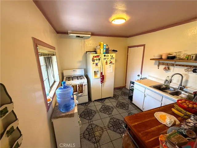 a view of a kitchen with fridge and workspace