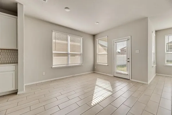 a view of an empty room with window and cabinet