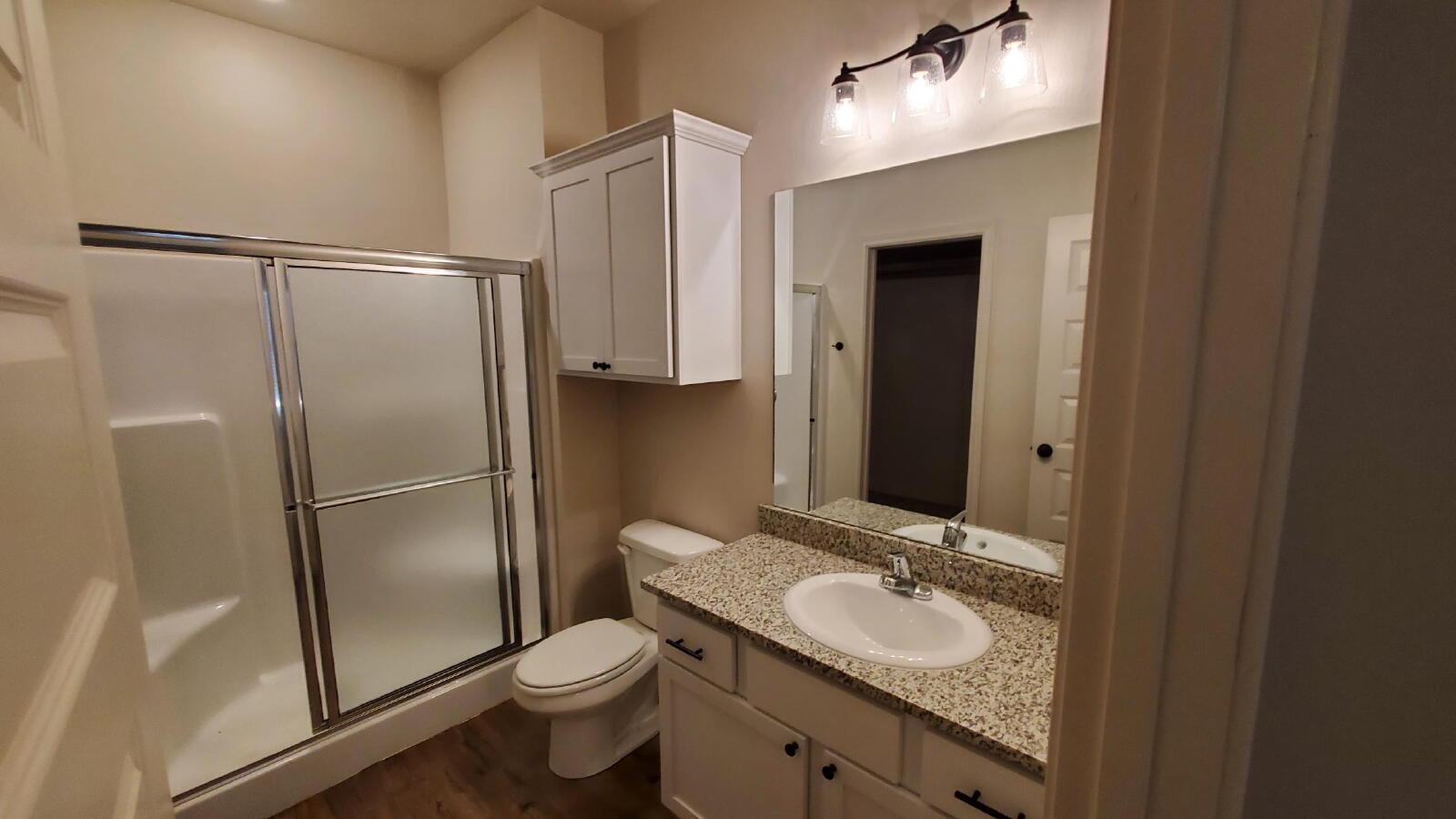 1230 North 7th Street Wolfforth, TX 79382 - Photo 12 of 16 a bathroom with a granite countertop sink toilet and shower