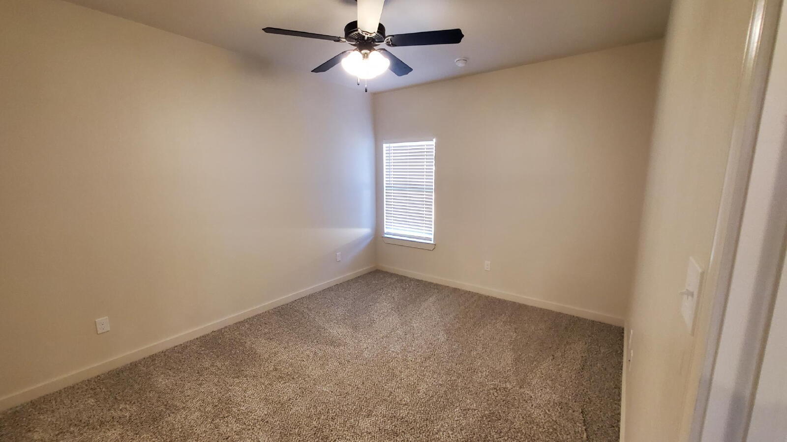 1230 North 7th Street Wolfforth, TX 79382 - Photo 13 of 16 an empty room with a window and ceiling fan