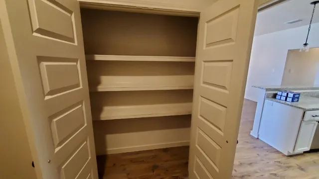 a view of walk in closet with empty racks