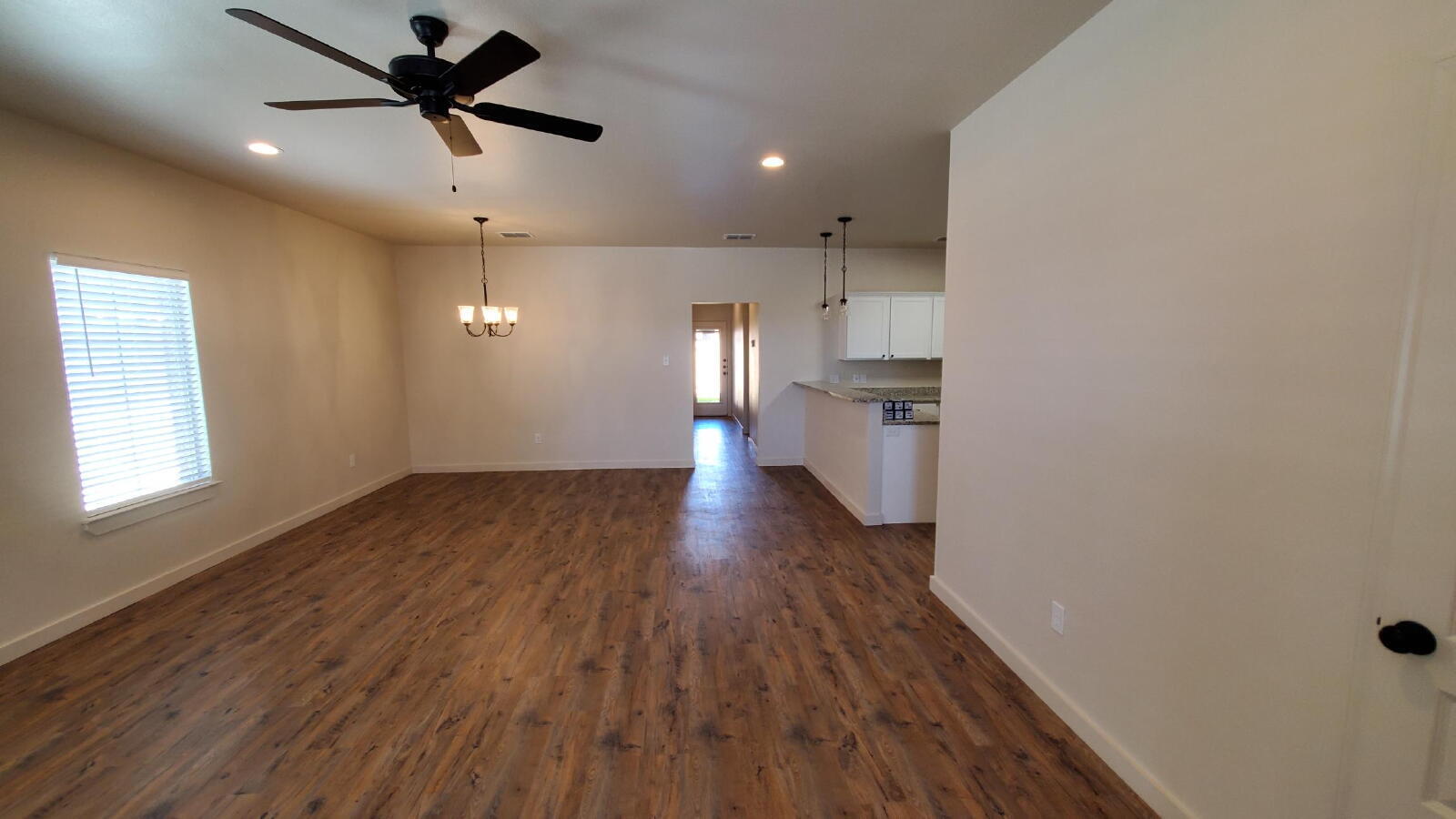 1230 North 7th Street Wolfforth, TX 79382 - Photo 2 of 16 an empty room with wooden floor and windows