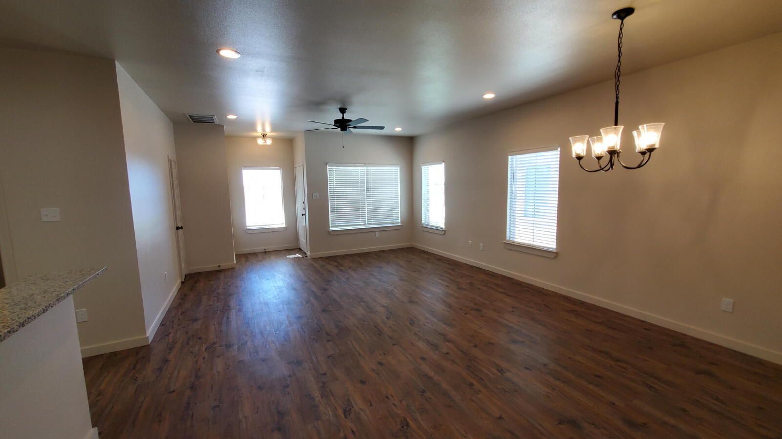 1230 North 7th Street Wolfforth, TX 79382 - Photo 3 of 16 an empty room with wooden floor and windows