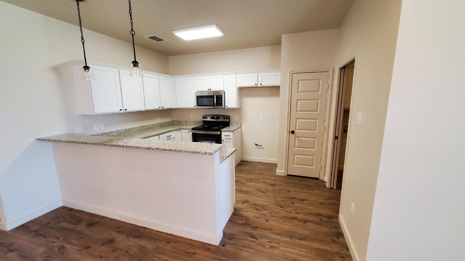 1230 North 7th Street Wolfforth, TX 79382 - Photo 4 of 16 a kitchen with refrigerator and cabinets