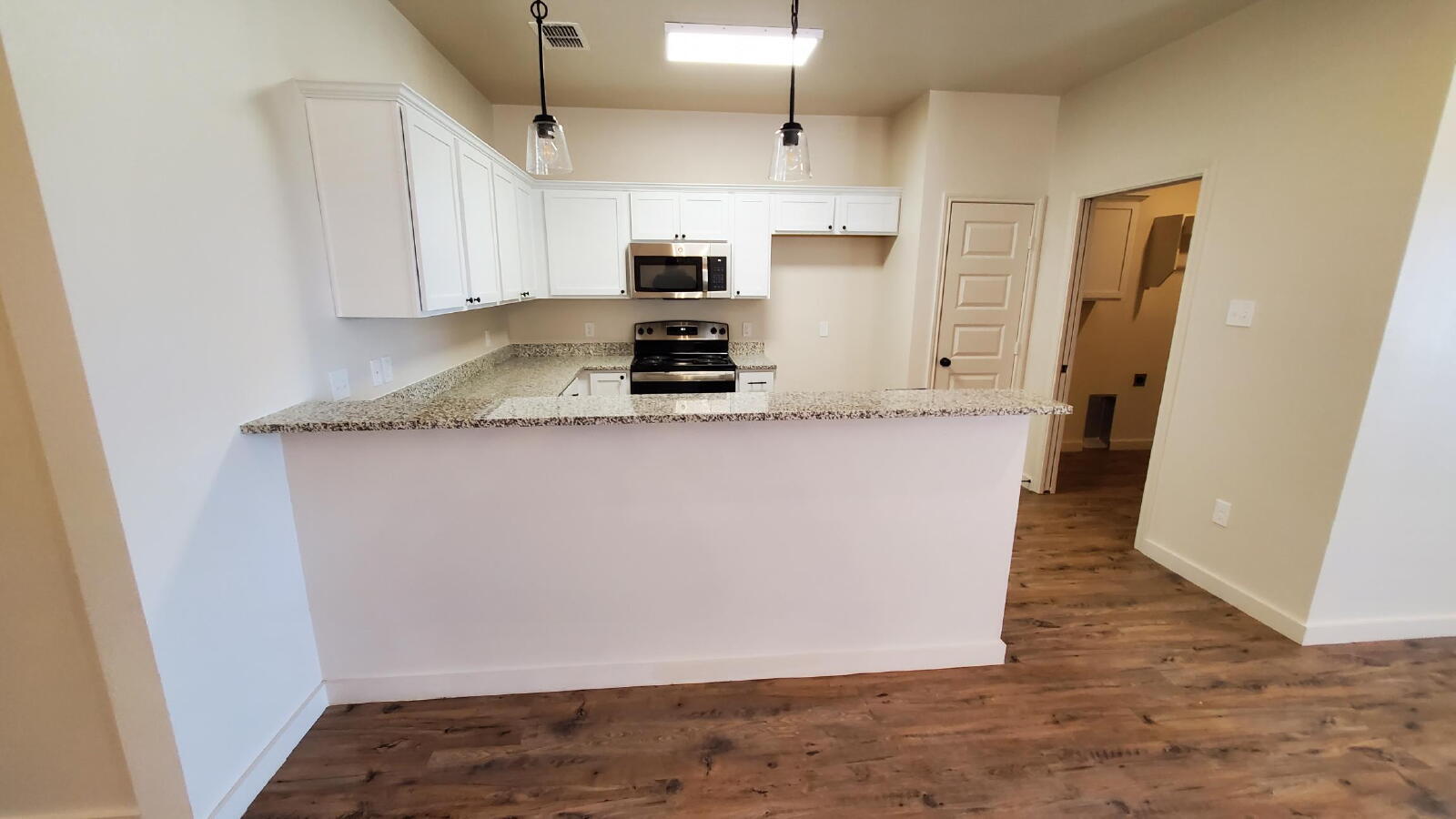 1230 North 7th Street Wolfforth, TX 79382 - Photo 5 of 16 a view of a kitchen with stainless steel appliances granite countertop a refrigerator a sink and a stove