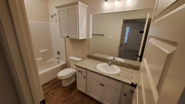 a bathroom with a granite countertop sink toilet and shower