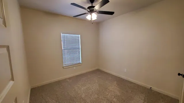 a view of a room with windows and ceiling fan