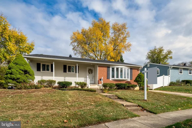 a front view of house with yard and trees in the background