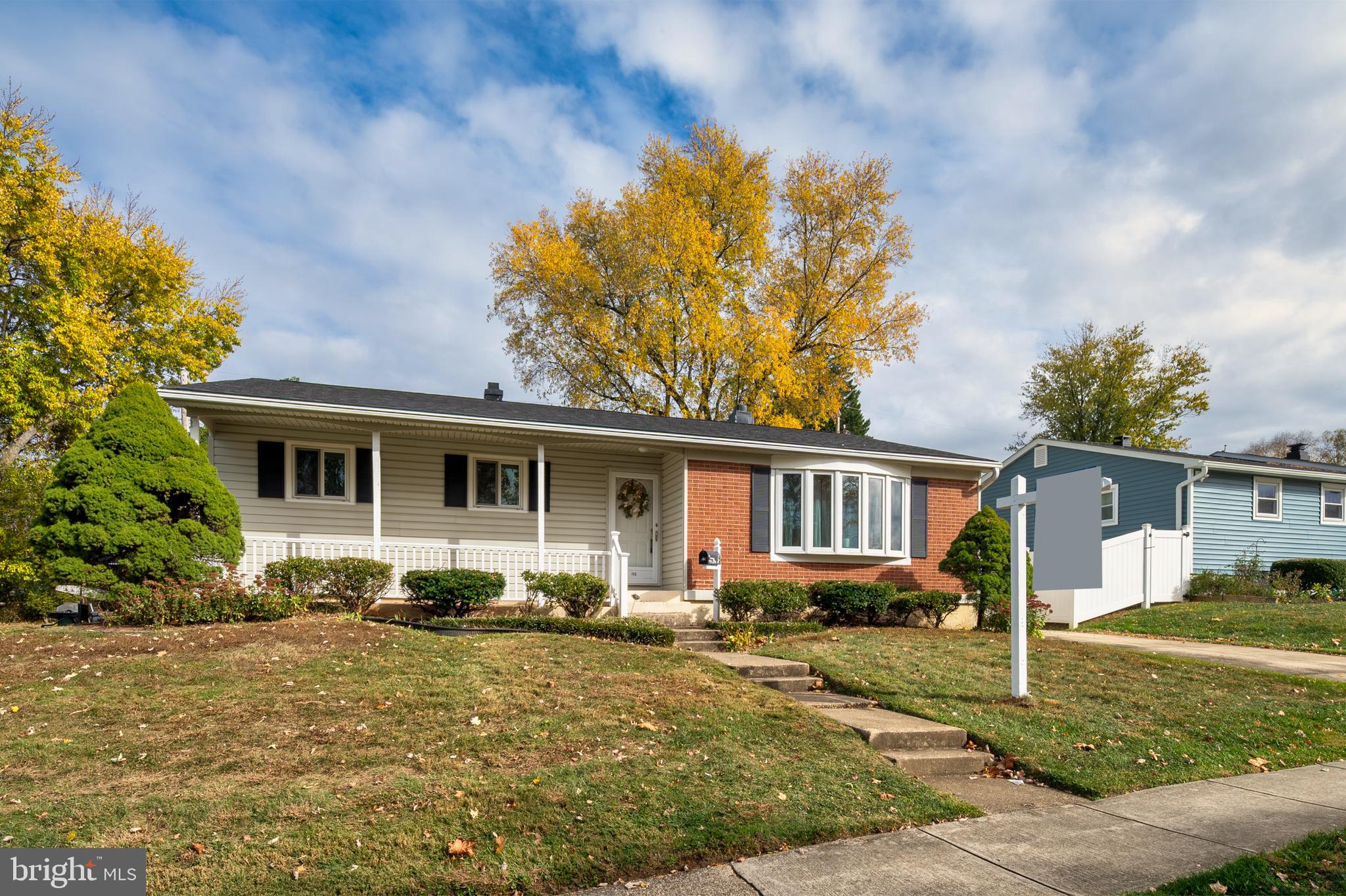 a front view of house with yard and trees in the background