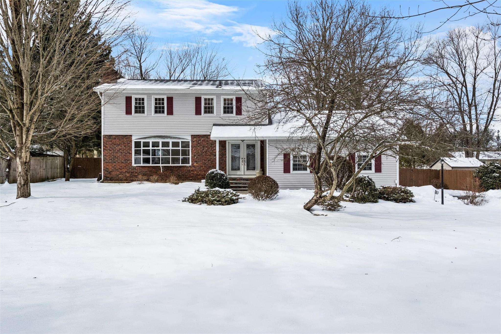 a view of a white house with a yard covered in snow