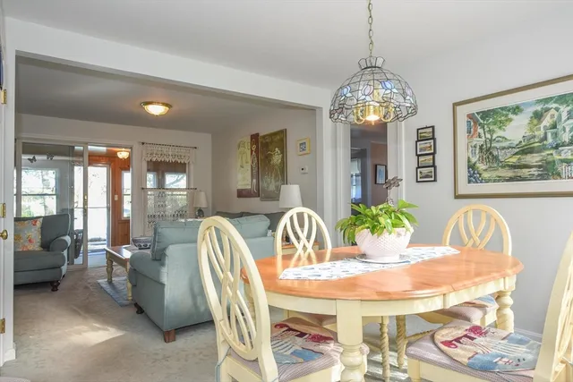 a view of a dining room with furniture a chandelier and large windows