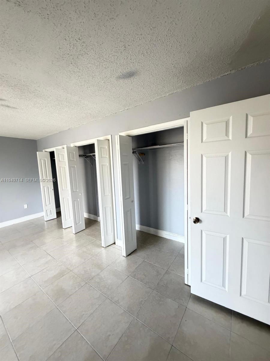 7010 Northwest 186th Street, Unit 5201 Hialeah, FL 33015 - Photo 17 of 29 an empty room with a fireplace and cabinet