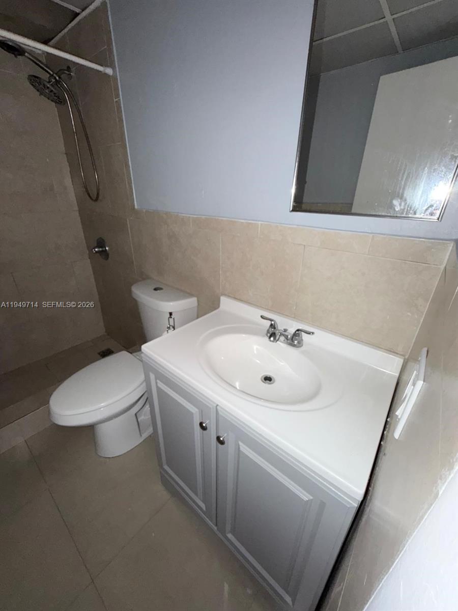 7010 Northwest 186th Street, Unit 5201 Hialeah, FL 33015 - Photo 19 of 29 a bathroom with a sink mirror and toilet