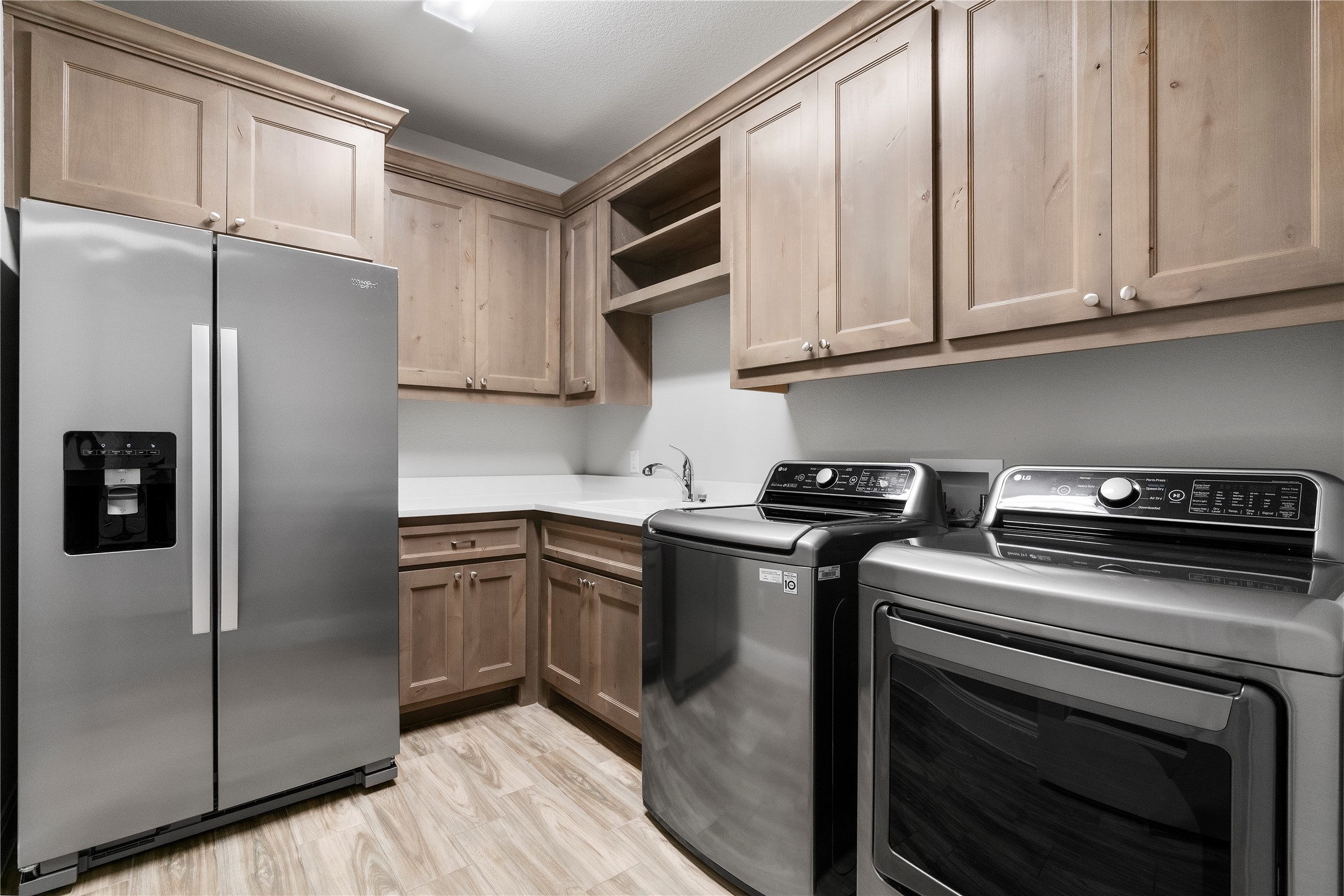 2033 Portobello Road Leander, TX 78641 - Photo 32 of 39 The laundry room includes abundant cabinetry, a sink, and refrigerator space.