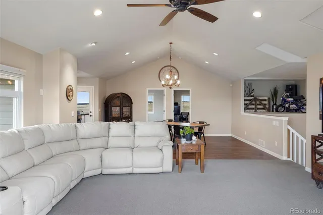 a kitchen with stainless steel appliances kitchen island granite countertop a dining table chairs and a refrigerator