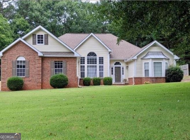 a front view of a house with yard and green space
