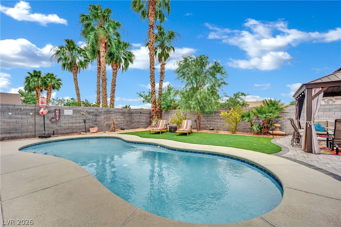 1724 Millstream Way Henderson, NV 89074 - Photo 40 of 60 An inviting backyard oasis awaits, featuring a refreshing swimming pool and a tranquil lounging area.
