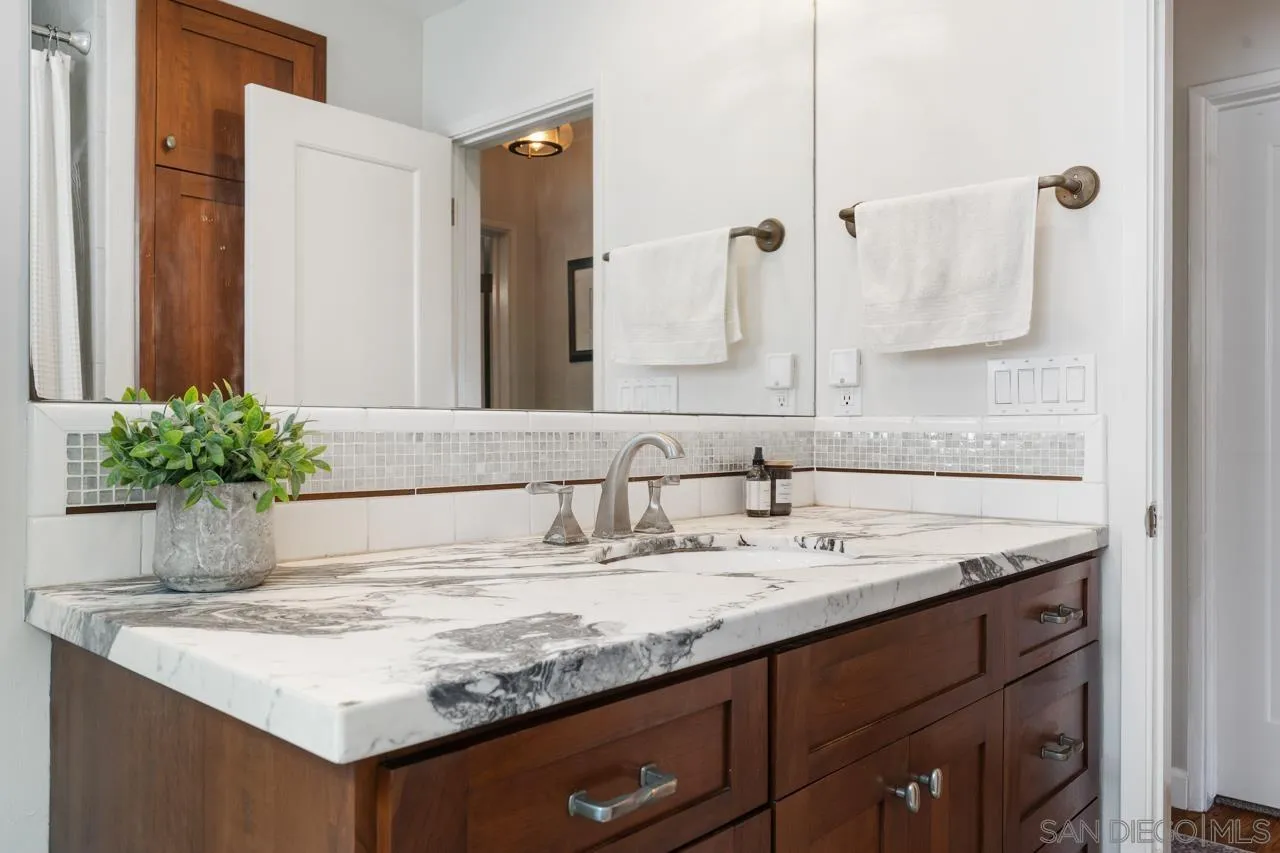 6365 Lambda Drive San Diego, CA 92120 - Photo 17 of 31 a bathroom with a granite countertop sink and a mirror