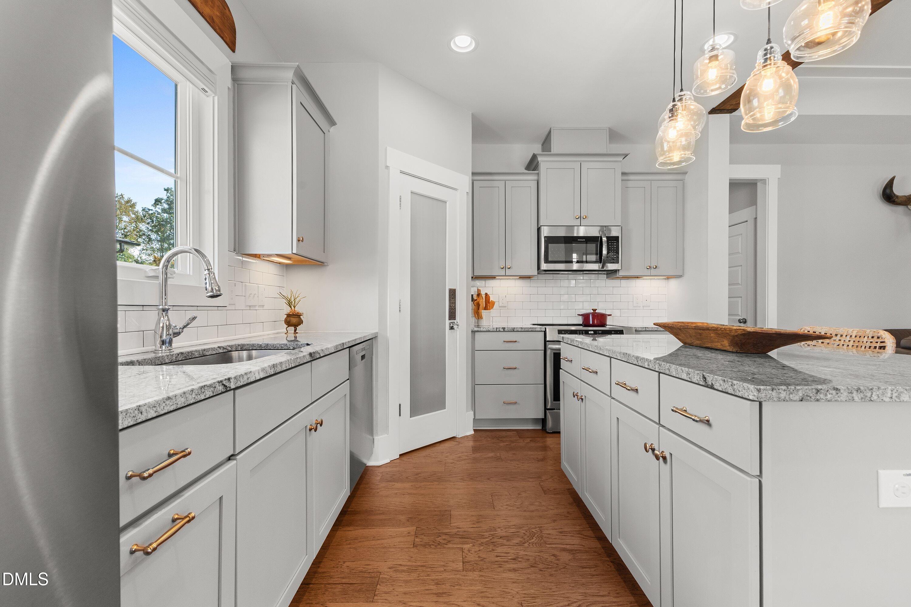 248 Old Hickory Drive Raleigh, NC 27603 - Photo 18 of 45 a kitchen with granite countertop a sink stove cabinets and refrigerator