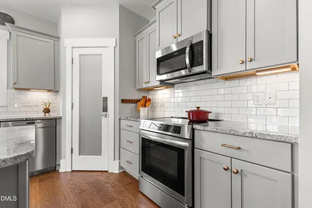 a kitchen with granite countertop a sink stove cabinets and refrigerator