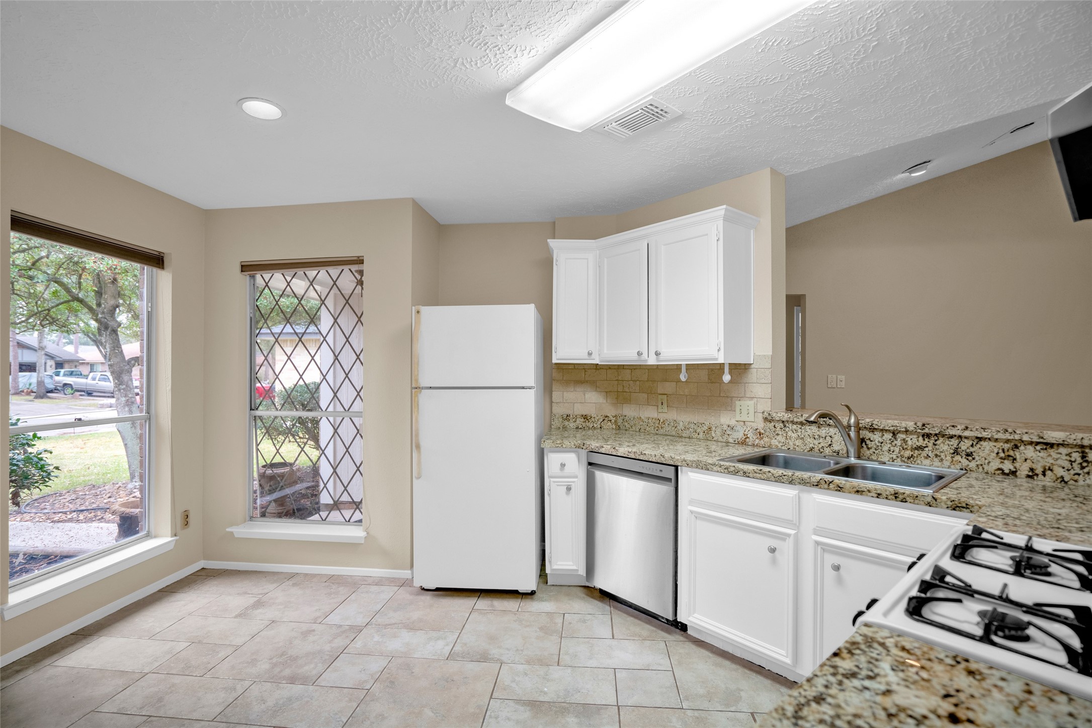 17323 Northchapel Street Spring, TX 77379 - Photo 14 of 37 Functional kitchen featuring stainless steel dishwasher, gas range, granite counters, and great cabinet space.