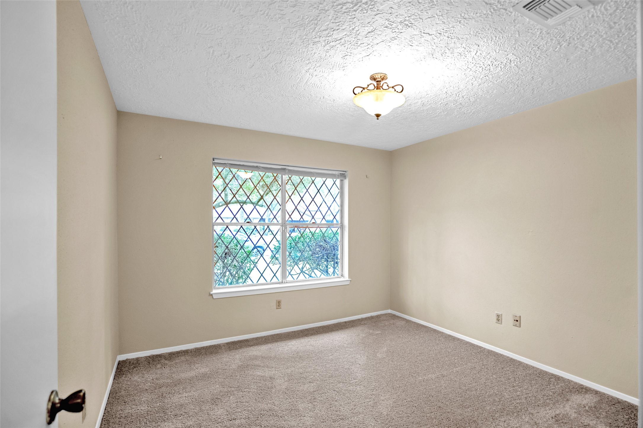 17323 Northchapel Street Spring, TX 77379 - Photo 18 of 37 Comfortable secondary bedroom with neutral tones, carpeted flooring, and natural light.