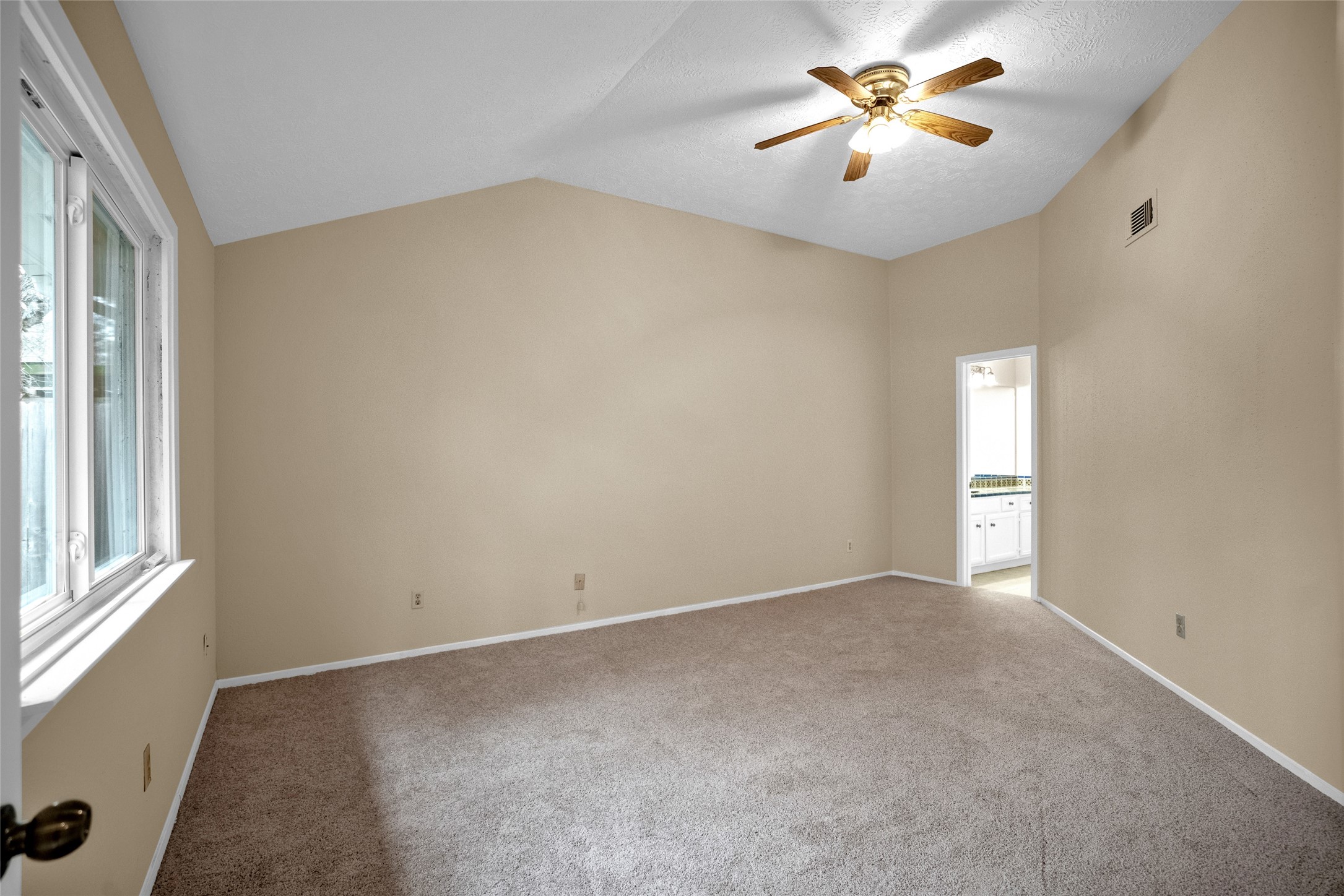17323 Northchapel Street Spring, TX 77379 - Photo 26 of 37 Large primary bedroom with vaulted ceiling, ceiling fan, and private access to en-suite bath.