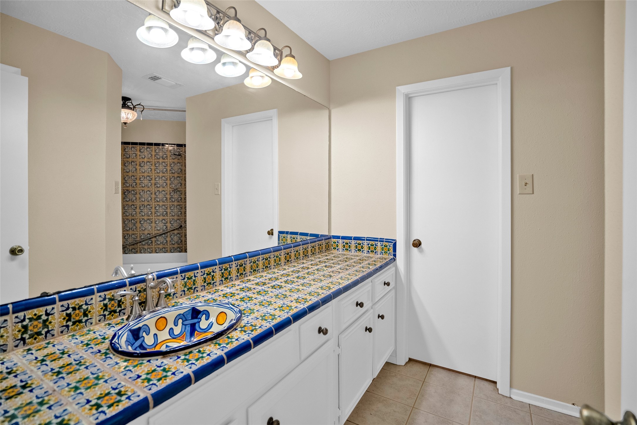 17323 Northchapel Street Spring, TX 77379 - Photo 29 of 37 Unique bathroom featuring custom tiled vanity, large mirror, and vintage-style finishes.