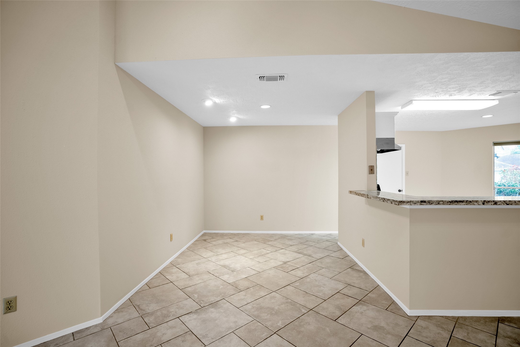 17323 Northchapel Street Spring, TX 77379 - Photo 9 of 37 Seamless flow from living room to kitchen with breakfast bar and ample natural light.