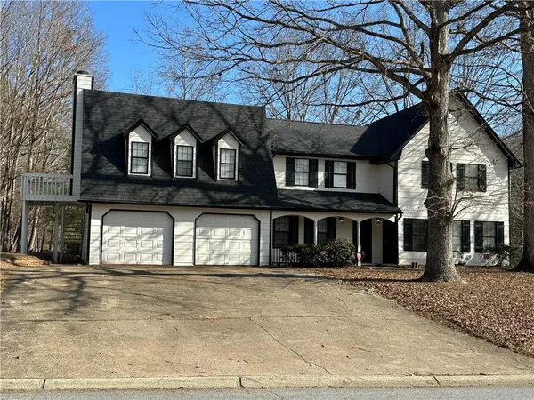 a front view of a house with a tree