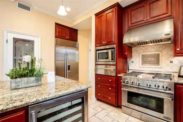 a kitchen with stainless steel appliances granite countertop a stove and a microwave