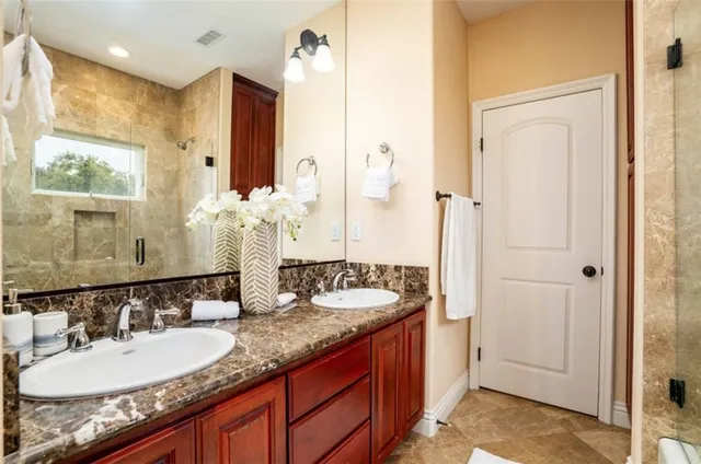 a bathroom with a granite countertop sink and a mirror