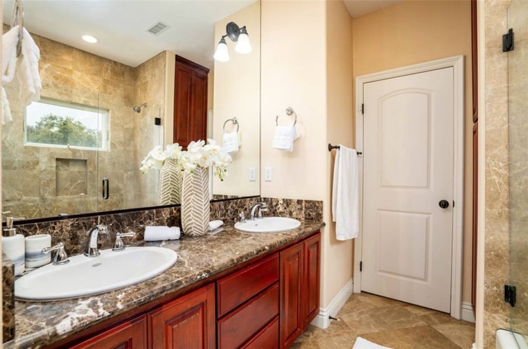 301 16th Street Huntington Beach, CA 92648 - Photo 4 of 16 a bathroom with a granite countertop sink and a mirror