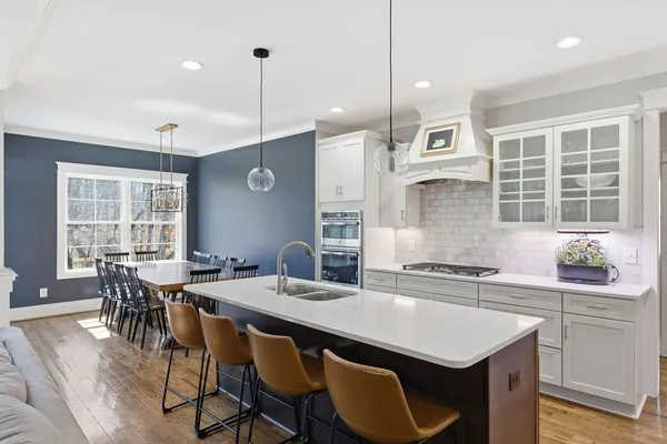 a kitchen with a dining table chairs and white cabinets