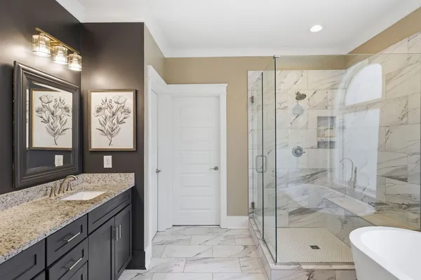 a bathroom with a granite countertop sink a mirror and a shower