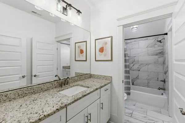 a bathroom with a granite countertop sink mirror bathtub and shower