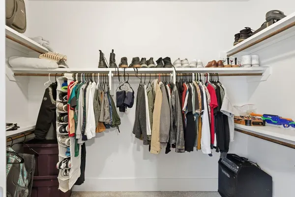 a view of walk in closet with clothes and shoes