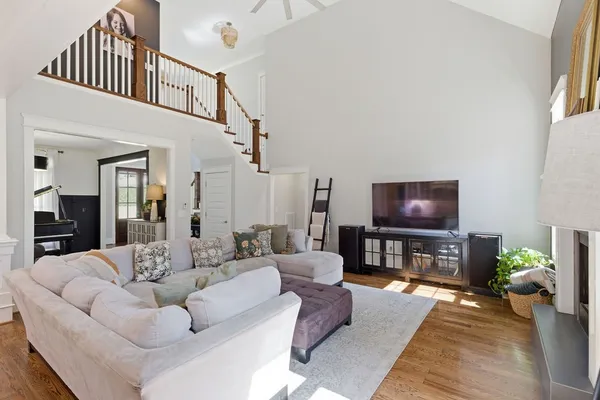 a living room with furniture a flat screen tv and a dining table