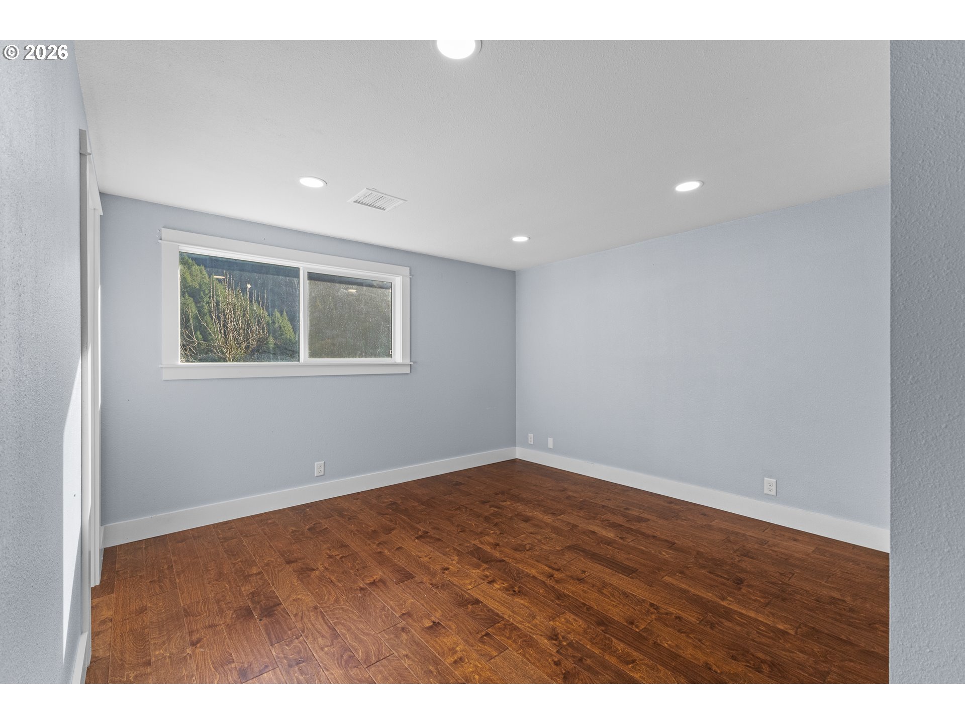 16855 Highway 42 Myrtle Point, OR 97458 - Photo 12 of 43 a view of an empty room with wooden floor and a window