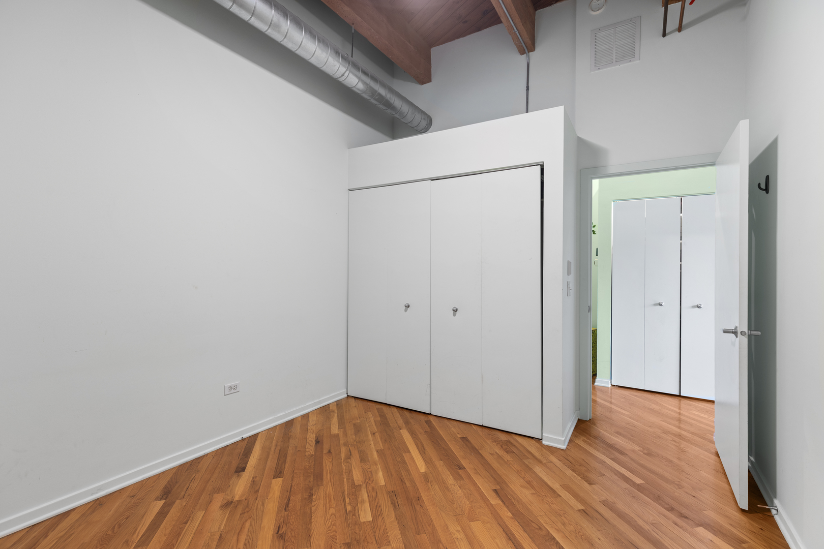 1040 West Adams Street, Unit 105 Chicago, IL 60607 - Photo 14 of 18 a view of an empty room with wooden floor