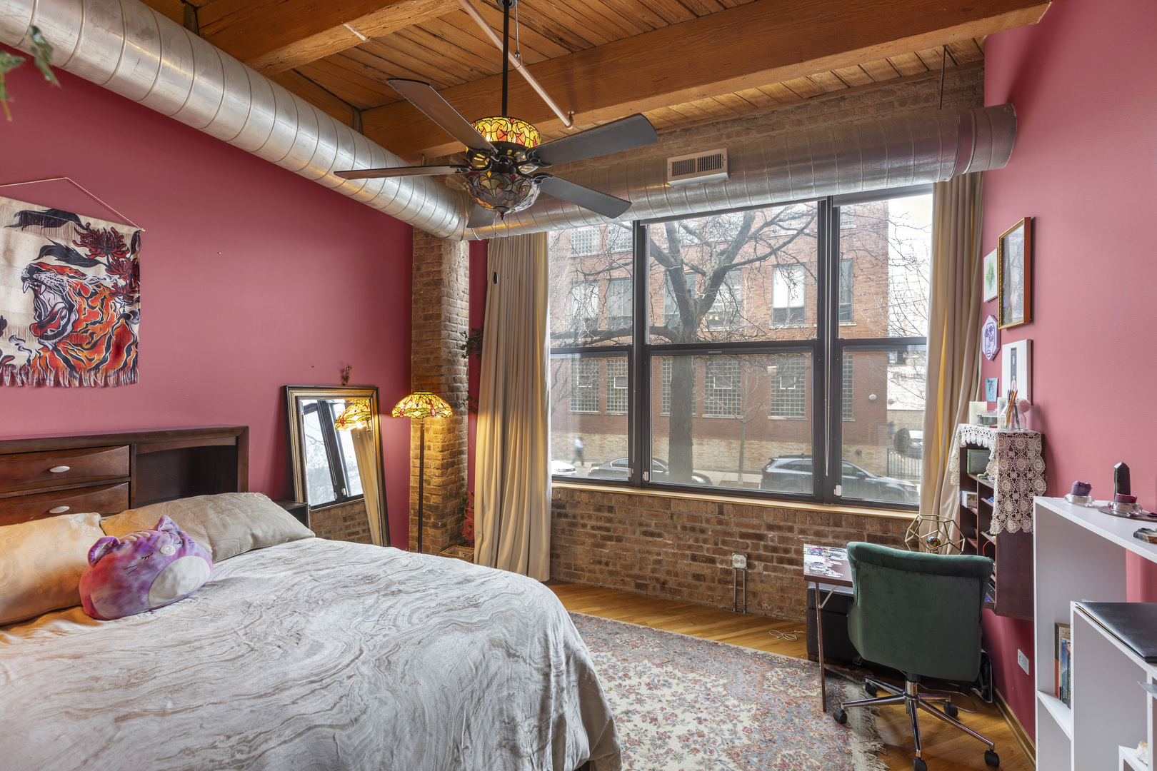 1040 West Adams Street, Unit 105 Chicago, IL 60607 - Photo 10 of 18 a bedroom with a bed and a chandelier