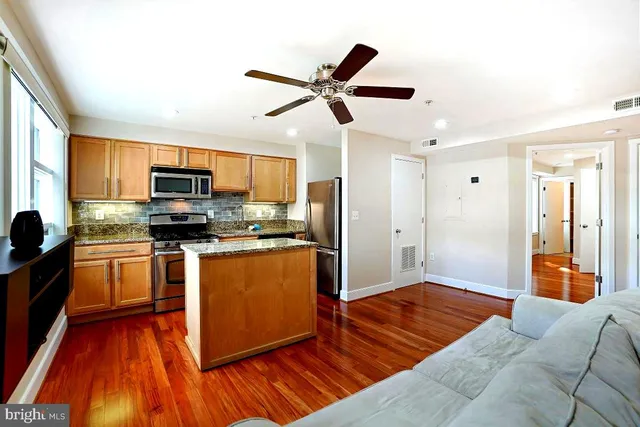 a kitchen with stainless steel appliances granite countertop a refrigerator a stove top oven a sink and dishwasher