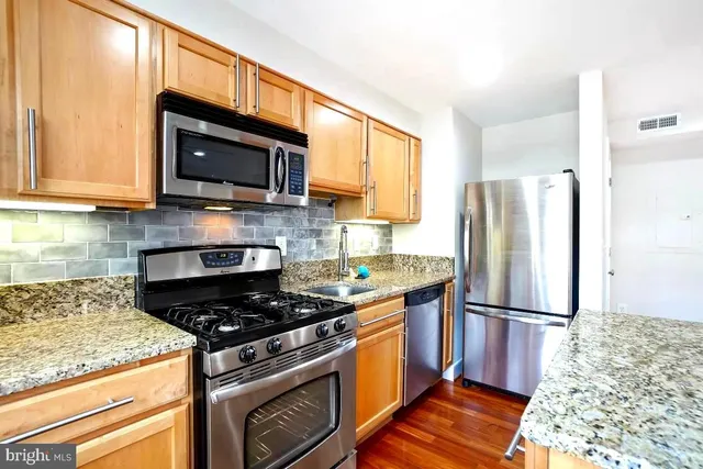 a kitchen with granite countertop a sink stove and refrigerator