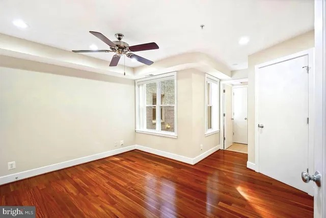 a view of a livingroom with wooden floor and a ceiling fan
