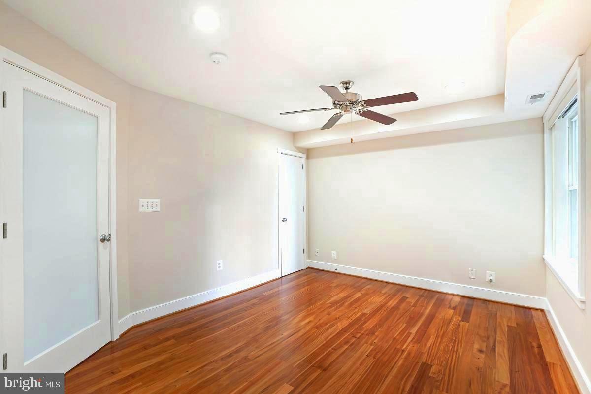 610 Jefferson Street Northwest, Unit 101 Washington, DC 20011 - Photo 17 of 24 an empty room with wooden floor and a ceiling fan