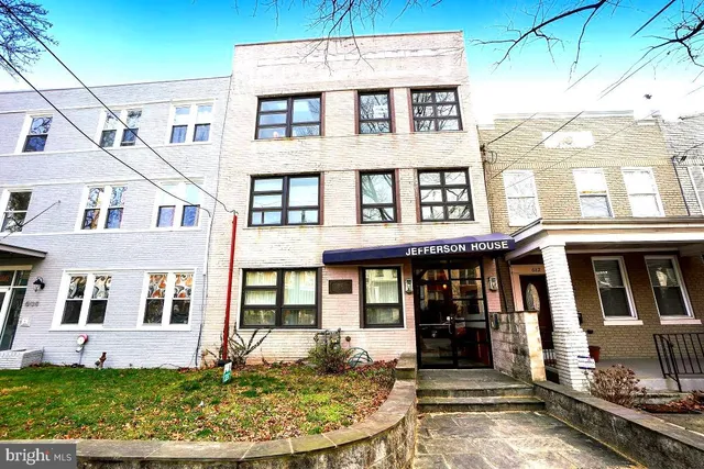 a front view of a residential apartment building with a yard